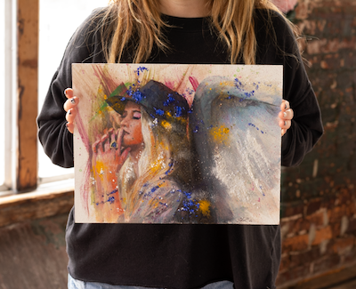 Model holding the 11x14" Original OIl painting of an angel praying the chaos.